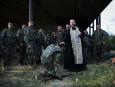 Duchowny udziela żołnierzom idącym na front komunii świętej i ostatniego namaszczenia